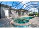 Outdoor oasis: Screened-in pool and spa offer a serene setting with patio, greenery, and privacy at 10487 Coquina Ct, Placida, FL 33946