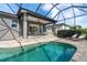 Beautiful pool and spa surrounded by brick pavers with a covered lanai and lush backyard views at 10487 Coquina Ct, Placida, FL 33946