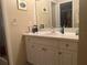 Well-lit bathroom featuring a white vanity, a large mirror, and ample counter space at 11029 Vanessa Ave, Englewood, FL 34224