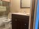 Cozy bathroom features a vanity with a marble countertop and a glass-enclosed tub at 11029 Vanessa Ave, Englewood, FL 34224