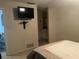 Bright bedroom featuring tiled floors, and tv, with a glimpse of the bathroom, offering a relaxing private retreat at 11029 Vanessa Ave, Englewood, FL 34224