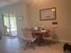 Cozy dining area featuring a round wooden table with swivel chairs, next to sliding glass doors leading to the patio at 11029 Vanessa Ave, Englewood, FL 34224