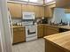 Functional kitchen featuring white appliances, tile flooring, and ample counter space at 11029 Vanessa Ave, Englewood, FL 34224