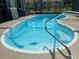 Inviting kidney shaped pool with access ladder in screened enclosure at 11029 Vanessa Ave, Englewood, FL 34224