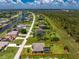Drone view highlighting the property, screened-in pool, backyard, and lush landscaping at 1119 Boundary Blvd, Rotonda West, FL 33947