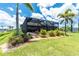 Spacious backyard with mature palm trees and lush landscaping surrounds a screened-in lanai, creating a private outdoor oasis at 1119 Boundary Blvd, Rotonda West, FL 33947