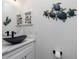 Bathroom vanity featuring a black vessel sink with a quartz countertop and decorative sea turtle art at 1119 Boundary Blvd, Rotonda West, FL 33947