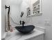 Bright bathroom features a black vessel sink with a quartz countertop and shelving for decor at 1119 Boundary Blvd, Rotonda West, FL 33947