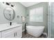 Bright bathroom with soaking tub, sleek vanity, and walk-in shower at 1119 Boundary Blvd, Rotonda West, FL 33947
