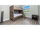 Comfortable bedroom features a wooden bunk bed, a window with a view, and hardwood floors at 1119 Boundary Blvd, Rotonda West, FL 33947