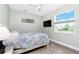 Cozy bedroom with a beach-themed decor, a mounted TV, and a bright window with neighborhood views at 1119 Boundary Blvd, Rotonda West, FL 33947
