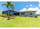Spacious backyard featuring a screened-in lanai, lush lawn, and beautiful landscaping, ideal for outdoor living and entertaining at 1119 Boundary Blvd, Rotonda West, FL 33947