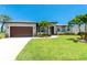 Beautiful single-story home featuring a well-manicured lawn, mature landscaping, and a two-car garage at 1119 Boundary Blvd, Rotonda West, FL 33947