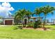 Charming single-story home with well-manicured lawn, mature palm trees, and attached garage, offering curb appeal at 1119 Boundary Blvd, Rotonda West, FL 33947
