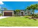 Well-manicured front lawn with palm trees highlights this home's great curb appeal at 1119 Boundary Blvd, Rotonda West, FL 33947
