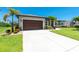 Home featuring a spacious driveway, manicured lawn, and a prominent two-car garage at 1119 Boundary Blvd, Rotonda West, FL 33947