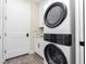 Convenient laundry room featuring a stacked washer and dryer, built-in cabinetry, and a sleek white door at 1119 Boundary Blvd, Rotonda West, FL 33947