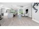 Bright living space showcasing wood-look floors, modern decor, and seamless flow to the kitchen at 1119 Boundary Blvd, Rotonda West, FL 33947
