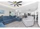 Living room area flows into the kitchen and dining areas, featuring large windows and a modern ceiling fan at 1119 Boundary Blvd, Rotonda West, FL 33947