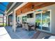 Inviting outdoor living area with stone floors, ceiling fans, flat screen tv, and dining space perfect for relaxing by the pool at 1119 Boundary Blvd, Rotonda West, FL 33947