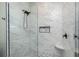 Luxurious shower with marble tiling, rain shower head, and storage niche at 1119 Boundary Blvd, Rotonda West, FL 33947