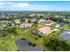 An aerial view showcases this home's landscaping, screened lanai, and tranquil pond at 117 Abercrombie Ave, Englewood, FL 34223