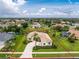 Expansive home boasts a manicured lawn, tile roof, and circular driveway in a lush, verdant neighborhood at 117 Abercrombie Ave, Englewood, FL 34223