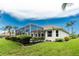 Well-maintained backyard featuring a screened-in lanai and lush landscaping at 117 Abercrombie Ave, Englewood, FL 34223