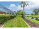 Well-manicured lawn featuring mature palms along the canal's edge at 117 Abercrombie Ave, Englewood, FL 34223