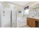 Bathroom with soaking tub, shower, vanity with cabinets, and a decorative window at 117 Abercrombie Ave, Englewood, FL 34223