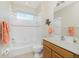 Full bathroom with shower-tub combo, white tile, and wooden vanity at 117 Abercrombie Ave, Englewood, FL 34223