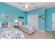 Bedroom with bright turquoise walls, two twin beds and neutral tile floors at 117 Abercrombie Ave, Englewood, FL 34223