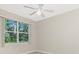 Bright bedroom with a ceiling fan and a window view of lush tropical foliage at 117 Abercrombie Ave, Englewood, FL 34223