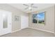 This bedroom has neutral walls, tile flooring, a ceiling fan, and a window with a backyard view at 117 Abercrombie Ave, Englewood, FL 34223