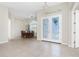 Spacious dining area featuring tile floors, a chandelier, and double doors leading to the outside at 117 Abercrombie Ave, Englewood, FL 34223