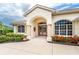 Inviting entryway features an arched entrance with double doors and decorative flower boxes and manicured landscaping at 117 Abercrombie Ave, Englewood, FL 34223