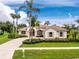 Well-manicured home boasts a circular driveway, tile roof, and lush landscaping at 117 Abercrombie Ave, Englewood, FL 34223