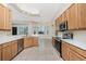 Well-lit kitchen is equipped with modern stainless-steel appliances, tile flooring and wooden cabinetry at 117 Abercrombie Ave, Englewood, FL 34223