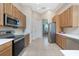 Well-lit kitchen features stainless steel appliances, and light-colored cabinets offering easy access to the dining room at 117 Abercrombie Ave, Englewood, FL 34223