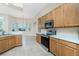 Bright kitchen features stainless steel appliances, wooden cabinetry and a breakfast bar in an open layout at 117 Abercrombie Ave, Englewood, FL 34223