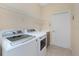Functional laundry room with modern appliances and storage shelving for convenience at 117 Abercrombie Ave, Englewood, FL 34223