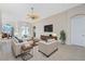 Sun-filled living room offers comfortable seating, a modern TV, and views to the outside dining area at 117 Abercrombie Ave, Englewood, FL 34223