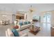 Open-concept living room with a dining area, and kitchen beyond the breakfast bar, features plenty of natural light at 117 Abercrombie Ave, Englewood, FL 34223