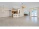 Bright, open-concept living room features a breakfast bar, dining area, and ceiling fan at 117 Abercrombie Ave, Englewood, FL 34223