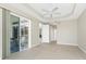View of a living room with tile floors, sliding glass doors to patio, and hall to bedrooms at 117 Abercrombie Ave, Englewood, FL 34223