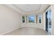 Bright living room boasts tray ceilings, a ceiling fan, and a view of the home's landscaping at 117 Abercrombie Ave, Englewood, FL 34223