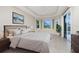Bright main bedroom with tray ceiling, bay window, and access to the pool at 117 Abercrombie Ave, Englewood, FL 34223