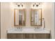 Bathroom featuring double sinks, framed mirrors, and modern lighting fixtures above a wood vanity at 11780 Anglers Club Dr # 107, Placida, FL 33946