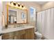 Well-lit bathroom with a vanity, a large mirror, and a shower with a white shower curtain at 11780 Anglers Club Dr # 107, Placida, FL 33946