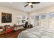 Bedroom with a ceiling fan, large window with blinds, and a desk with a computer at 11780 Anglers Club Dr # 107, Placida, FL 33946